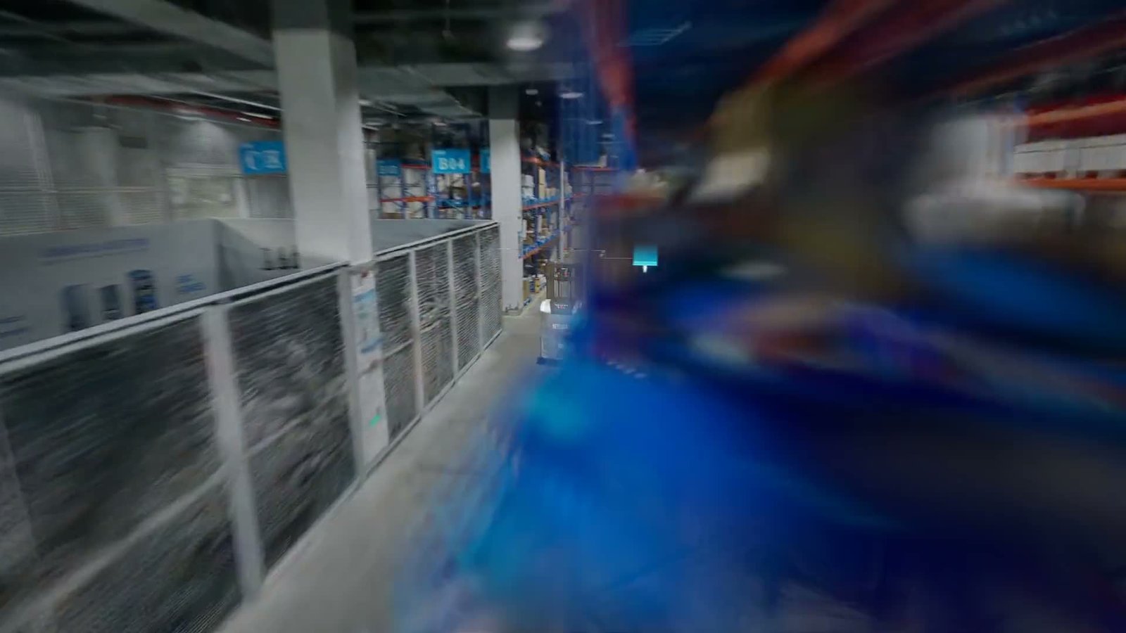 AGV de carretilla elevadora automatizada transportando un palé cargado dentro de un gemelo digital fotorrealista de un almacén del Reino Unido